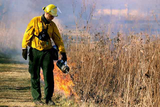 Пожарный применяет огнетушитель для тушения пожара